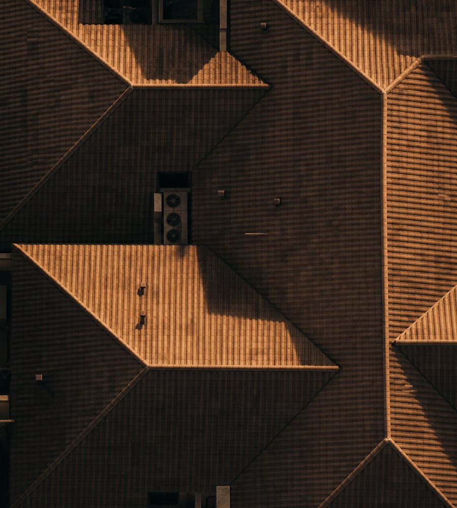 Aerial view of apartment rooflines in low afternoon light